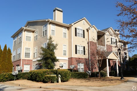 an apartment building on a street corner with a blue sky